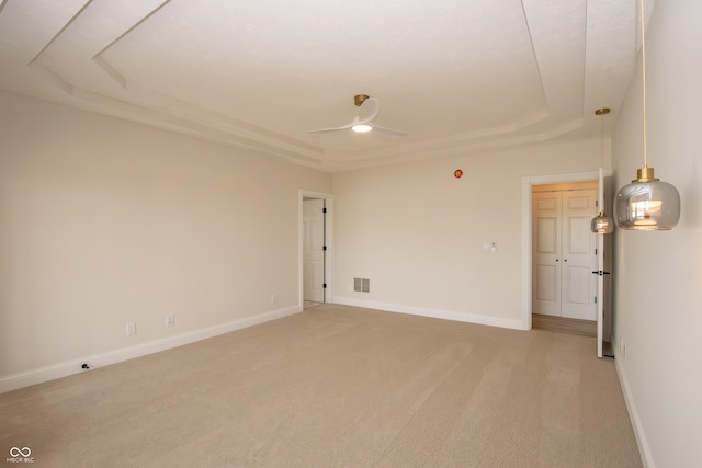 12520 E Stanley Rd, Selma, IN 47383 - spare room with light carpet, a ceiling fan, baseboards, a tray ceiling, and visible vents