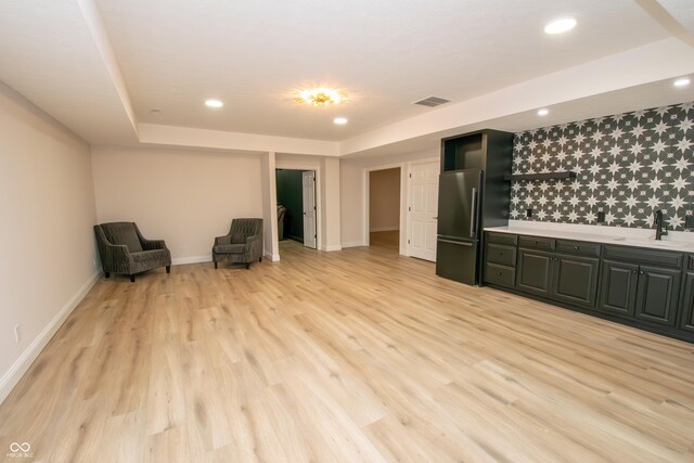 12520 E Stanley Rd, Selma, IN 47383 - interior space with visible vents, baseboards, light wood-style floors, a tray ceiling, and a sink