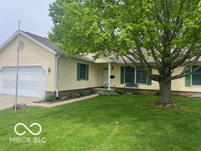 single story home featuring driveway, a front lawn, and a garage