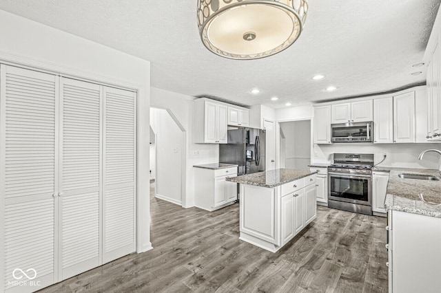 kitchen featuring recessed lighting, a sink, white cabinets, and stainless steel appliances