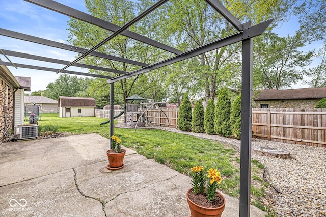 view of patio / terrace with central air condition unit, an outbuilding, a fenced backyard, and a playground