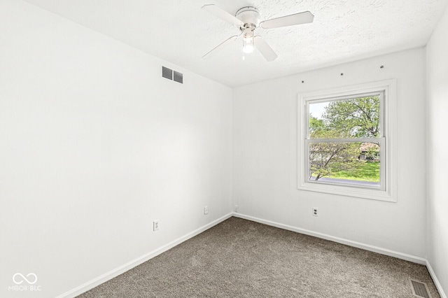 carpeted empty room with visible vents, a ceiling fan, and baseboards