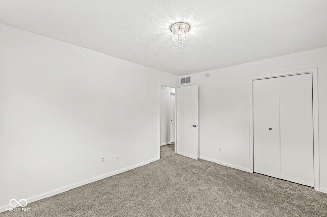 unfurnished bedroom with baseboards, visible vents, carpet, and a closet