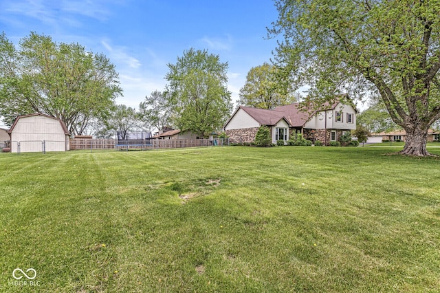 view of yard with a barn and fence