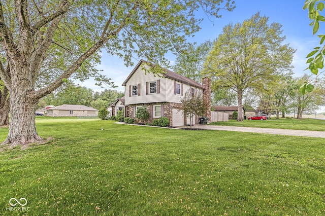 view of front of house featuring a garage, a front lawn, a chimney, brick siding, and driveway