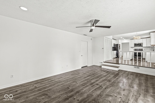 unfurnished living room with visible vents, ceiling fan, dark wood-style floors, recessed lighting, and a textured ceiling
