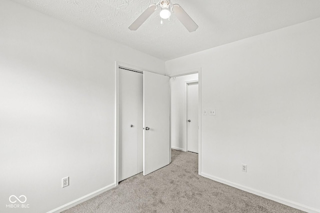 unfurnished bedroom with baseboards, ceiling fan, carpet, and a closet