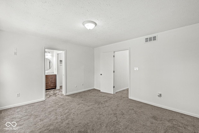 unfurnished bedroom featuring carpet flooring, a textured ceiling, visible vents, and baseboards