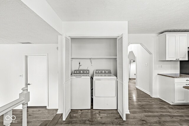 laundry room with separate washer and dryer, laundry area, dark wood-style floors, and a textured ceiling