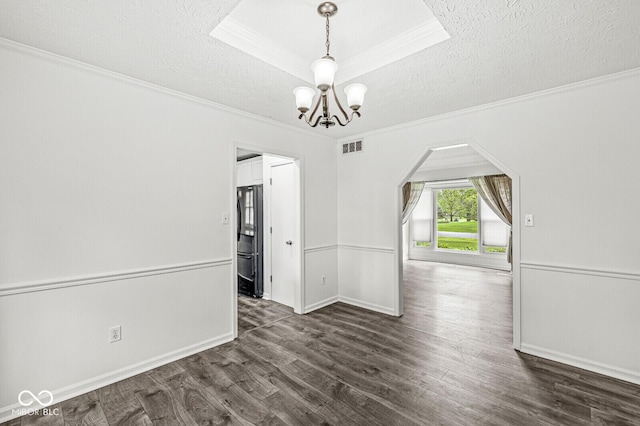 unfurnished room with crown molding, arched walkways, a textured ceiling, and a chandelier