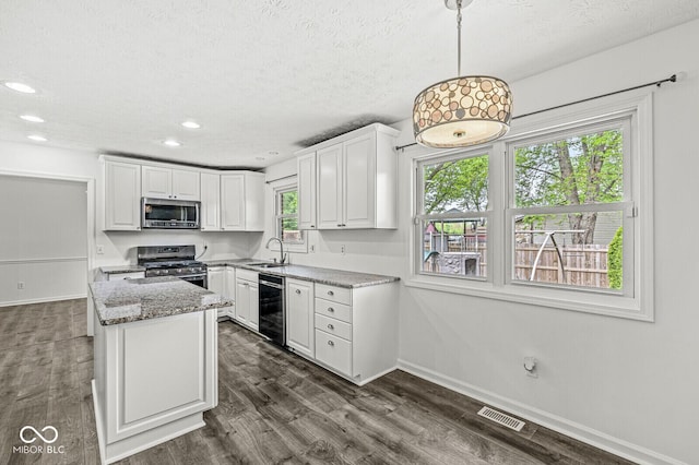 kitchen with visible vents, a sink, baseboards, stainless steel appliances, and white cabinetry