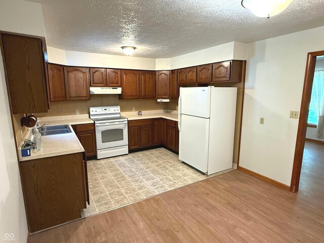 3282 S Conservation Club Rd, Morgantown, IN 46160 - kitchen featuring white appliances, under cabinet range hood, light wood-style floors, a textured ceiling, and light countertops