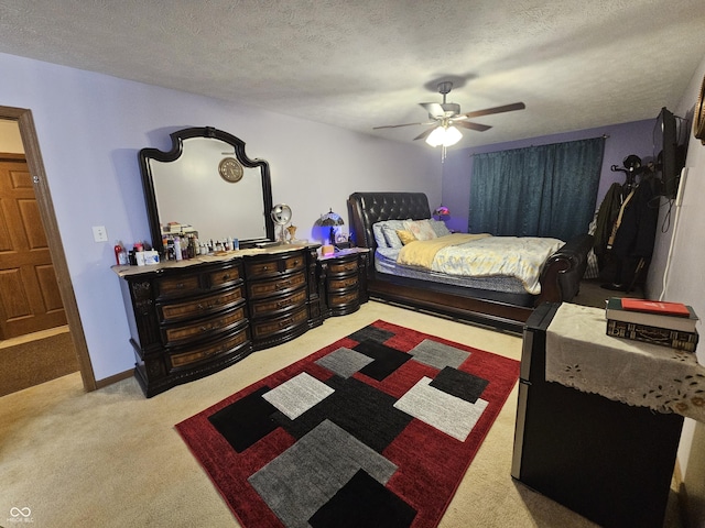 bedroom featuring a ceiling fan, a textured ceiling, and light carpet
