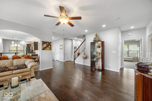 5136 Centerview Dr, Battle Ground, IN 47920 - living room featuring stairs, arched walkways, wood finished floors, and ceiling fan with notable chandelier