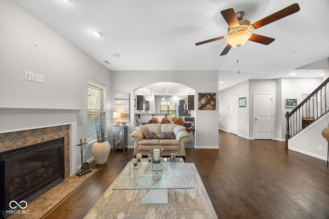 5136 Centerview Dr, Battle Ground, IN 47920 - living room with dark wood-style flooring, baseboards, ceiling fan, stairway, and arched walkways