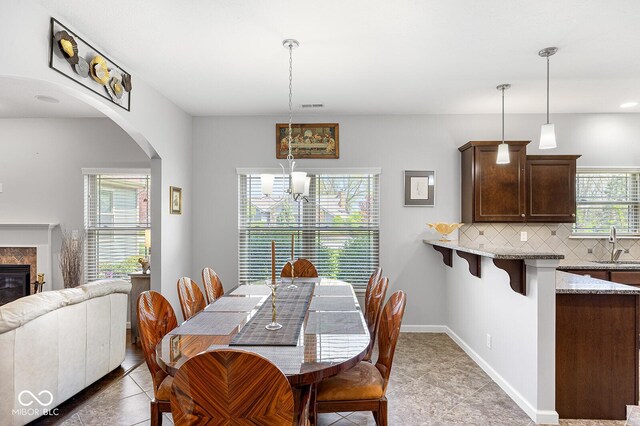 5136 Centerview Dr, Battle Ground, IN 47920 - dining space featuring arched walkways, a chandelier, baseboards, light tile patterned floors, and visible vents