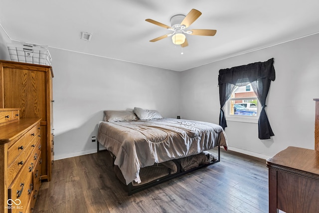 bedroom with dark wood-style flooring, baseboards, visible vents, and a ceiling fan