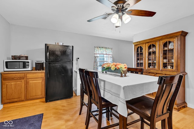 dining room featuring a ceiling fan and light wood-style flooring