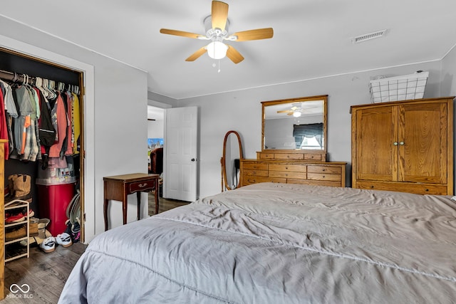 bedroom with ceiling fan, a closet, wood finished floors, and visible vents