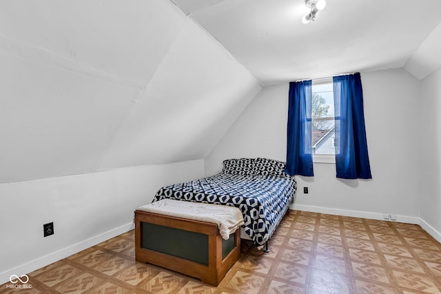 bedroom with baseboards and lofted ceiling