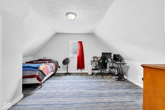 bedroom featuring baseboards, a textured ceiling, wood finished floors, and lofted ceiling