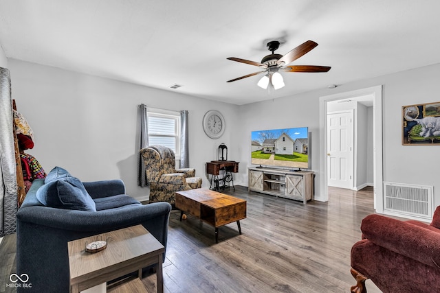 living area with ceiling fan, visible vents, and wood finished floors