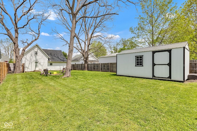 view of yard with an outdoor structure, a fenced backyard, and a shed