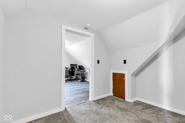 additional living space featuring baseboards, carpet, and vaulted ceiling