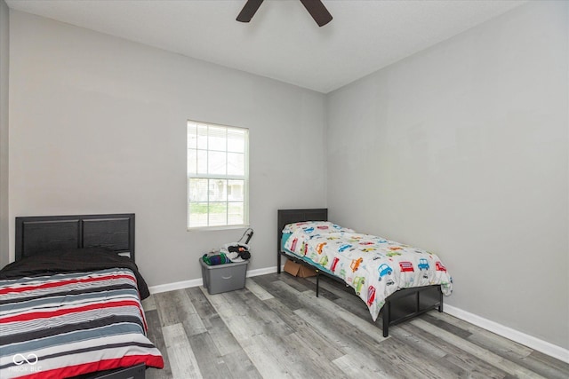 bedroom featuring baseboards, ceiling fan, and wood finished floors