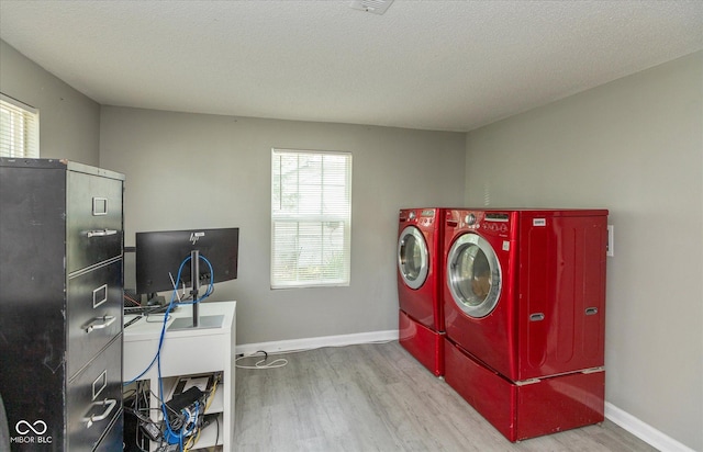 laundry area featuring baseboards, laundry area, wood finished floors, and washer and dryer