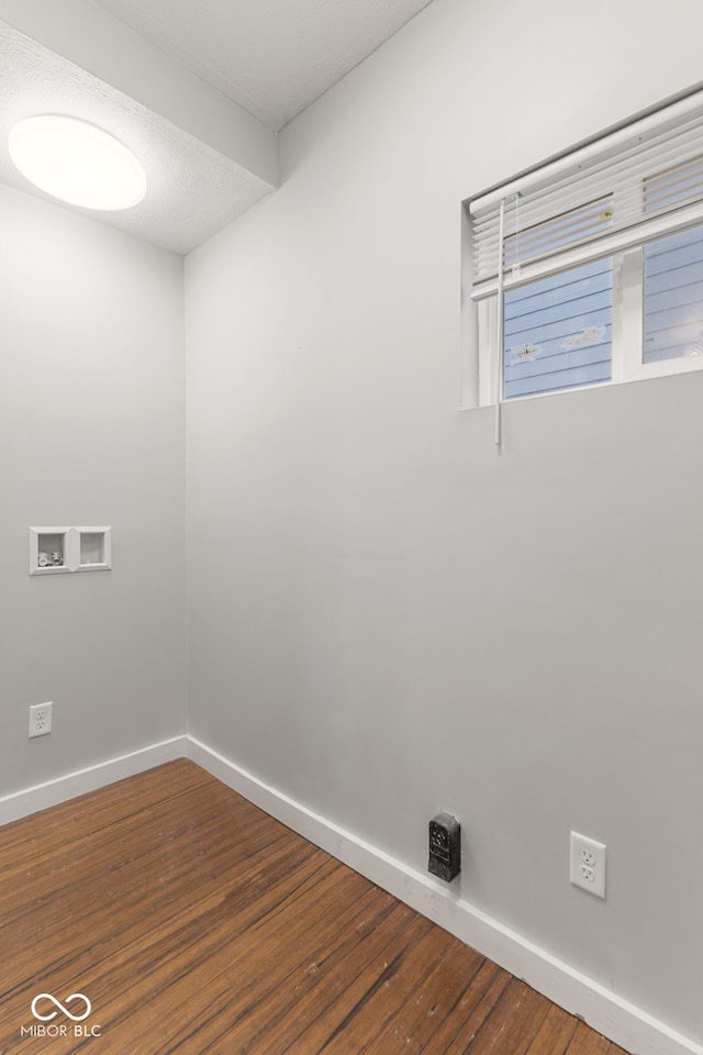 unfurnished room with baseboards and wood finished floors