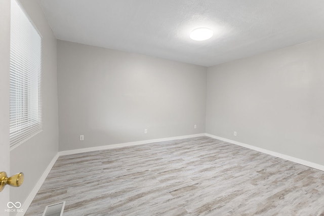 empty room with a healthy amount of sunlight and wood finished floors