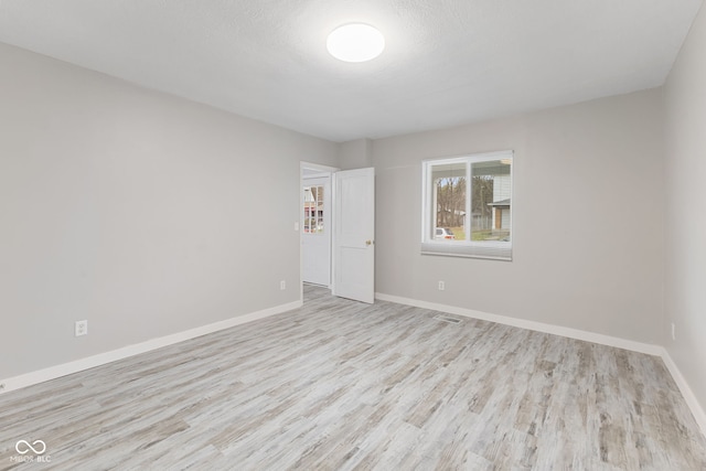 empty room with baseboards and wood finished floors