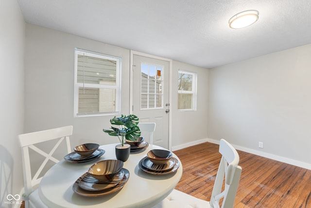 dining area with baseboards and wood finished floors