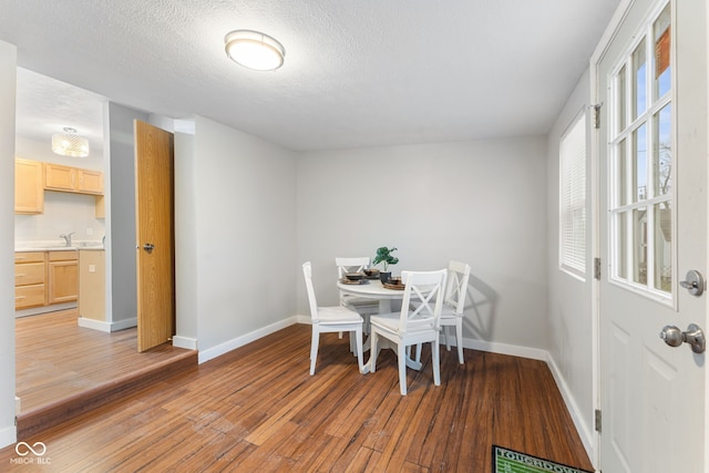 dining space featuring a textured ceiling, baseboards, visible vents, and light wood-style flooring