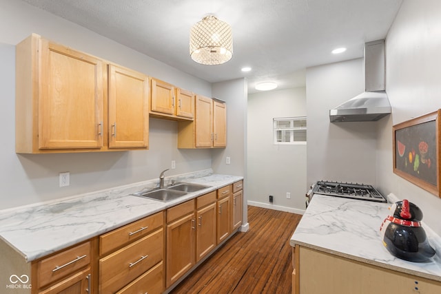 kitchen with baseboards, stainless steel gas range oven, wall chimney range hood, dark wood-type flooring, and a sink