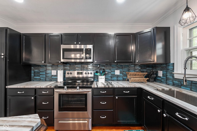 155 N Franklin Rd, Indianapolis, IN 46219 - kitchen with pendant lighting, dark cabinetry, a sink, backsplash, and stainless steel appliances