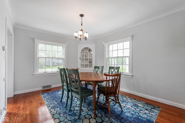 155 N Franklin Rd, Indianapolis, IN 46219 - dining room with visible vents, crown molding, wood finished floors, baseboards, and an inviting chandelier