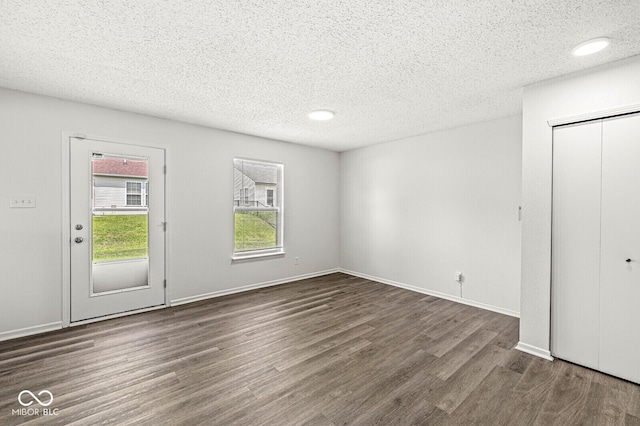 interior space with a textured ceiling and wood finished floors