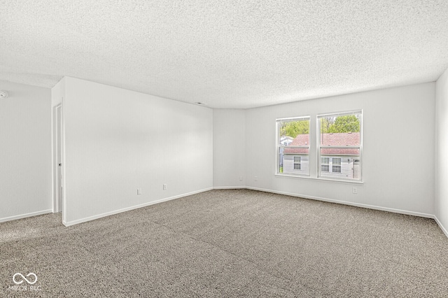 carpeted spare room with baseboards and a textured ceiling
