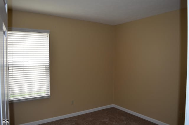 5708 Outer Bank Rd, Indianapolis, IN 46239 - empty room with dark colored carpet and baseboards