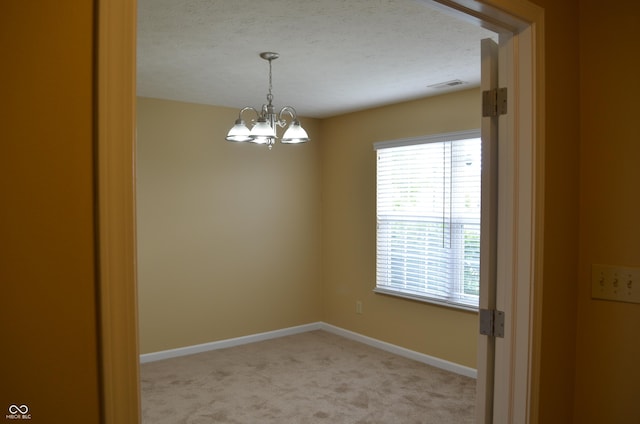 5708 Outer Bank Rd, Indianapolis, IN 46239 - unfurnished room featuring light colored carpet, a chandelier, and a textured ceiling