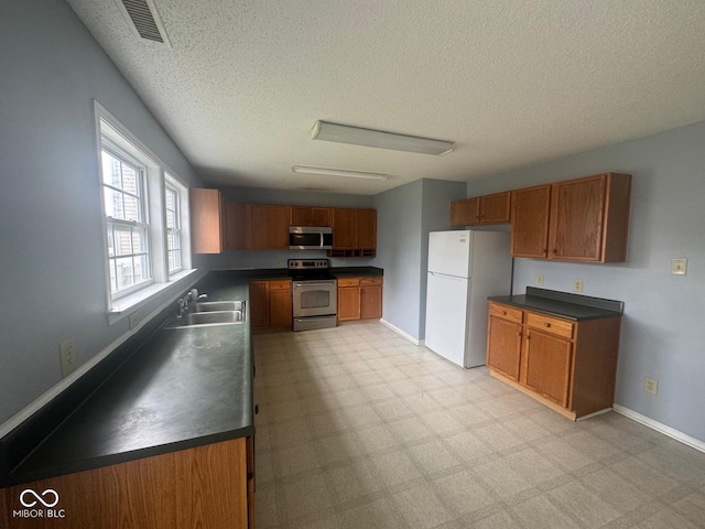 317 Legacy Blvd, Greenwood, IN 46143 - kitchen with dark countertops, stainless steel appliances, and a textured ceiling