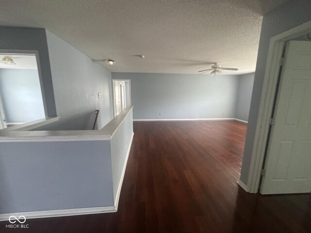 317 Legacy Blvd, Greenwood, IN 46143 - hall with baseboards, an upstairs landing, a textured ceiling, and dark wood-type flooring