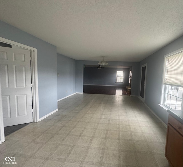 317 Legacy Blvd, Greenwood, IN 46143 - spare room featuring baseboards, a textured ceiling, and a chandelier