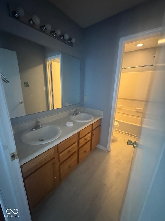 317 Legacy Blvd, Greenwood, IN 46143 - full bathroom with double vanity, toilet, a sink, and wood finished floors