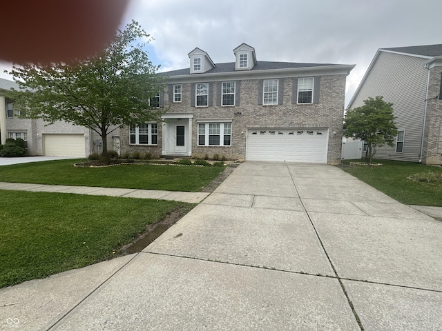 317 Legacy Blvd, Greenwood, IN 46143 - view of front of house featuring brick siding, an attached garage, driveway, and a front yard