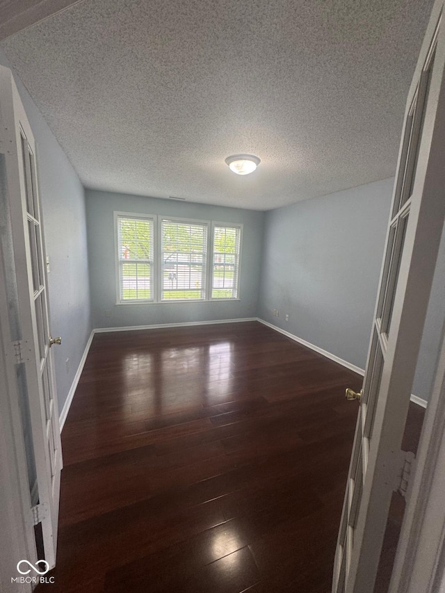 317 Legacy Blvd, Greenwood, IN 46143 - unfurnished room featuring baseboards, dark wood-style floors, and a textured ceiling