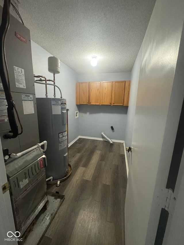 317 Legacy Blvd, Greenwood, IN 46143 - washroom featuring baseboards, dark wood-type flooring, a textured ceiling, electric water heater, and cabinet space