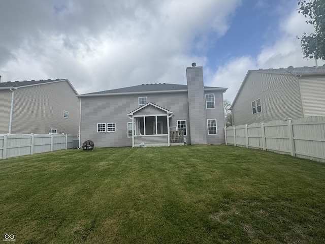 317 Legacy Blvd, Greenwood, IN 46143 - back of property with a fenced backyard, a sunroom, a chimney, and a lawn
